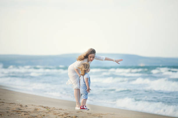istock Mother and son walking on the beach 688997402