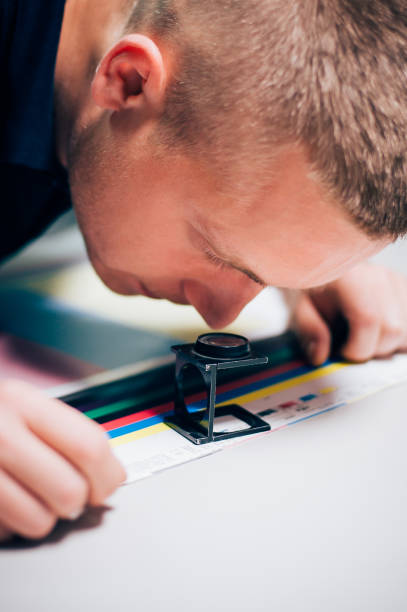 istock Worker in printing and press centar uses a magnifying glass 688999736