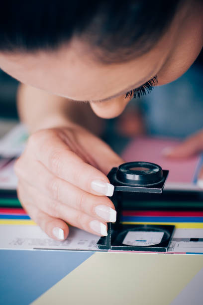 istock Worker in printing and press centar uses a magnifying glass 689000090
