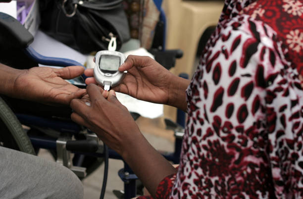 Nurse checking Blood sugar level of woman in a medical camp during happy roads program(vehicular Traffic stopped) in necklace road,Hyderabad,India. stock photo