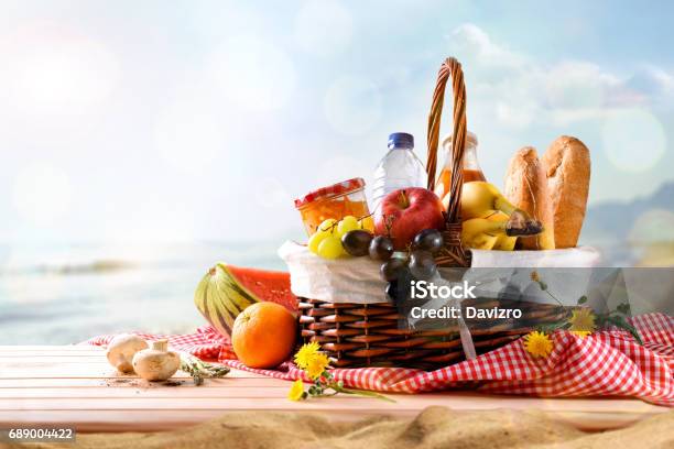 Picnic Wicker Basket With Food On Table On The Beach Stock Photo - Download Image Now