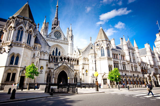 Royal Courts of Justice London, UK, May 2017, Exterior of the famous Royal Courts of Justice in London, viewed across the Strand with a tourist on the zebra crossing in the foreground. It is the home of the High Court and the Court of Appeal and was designed by George Edmund Street who died before its completion. royal courts of justice stock pictures, royalty-free photos & images