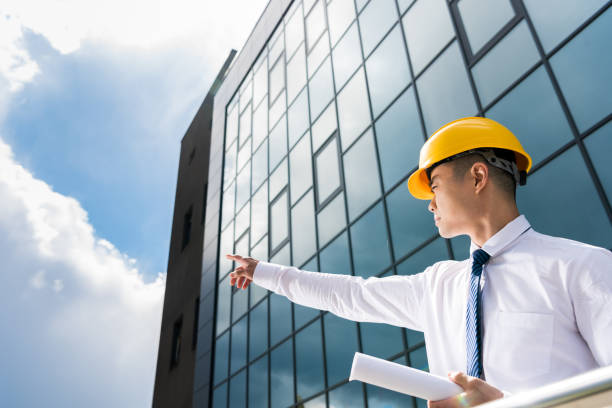 istock side view of professional architect in hard hat holding blueprint and gesturing 689011714