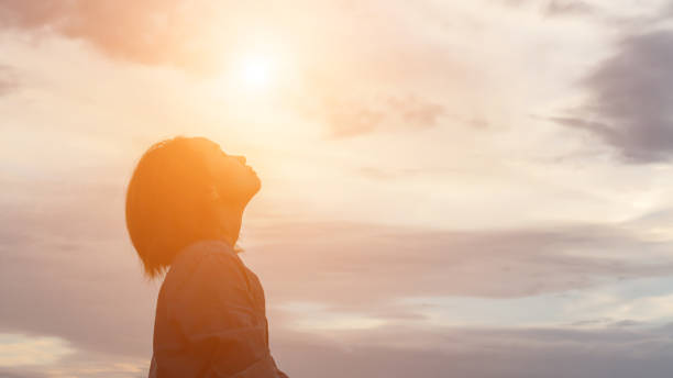 silhouette von frau beten auf den schönen himmel hintergrund - anmut stock-fotos und bilder