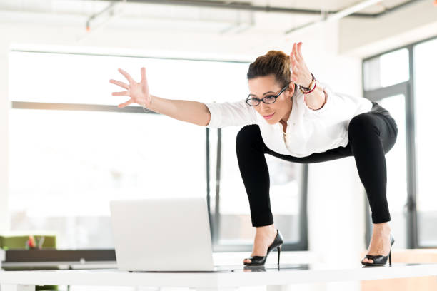 istock Cheerful female doing gymnastics at job 689022984