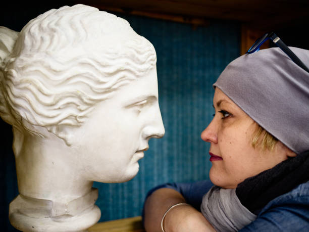 istock Mature woman looking at statue 689023160