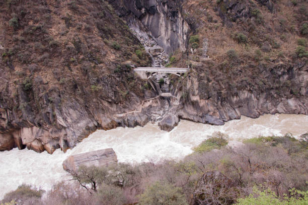 tigre pulando desfiladeiro localizado ao norte da cidade de lijiang, província de yunnan, china - salta province - fotografias e filmes do acervo