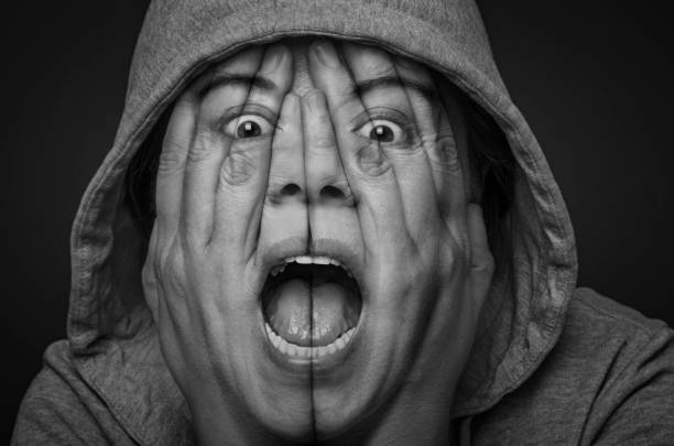 Surreal portrait of a desperate woman covering her face and eyes with her hands. Depression and frustration concept. Double exposure. Black and White.