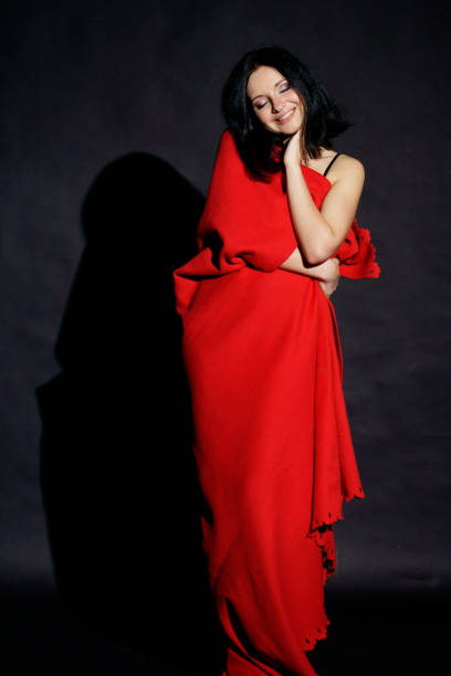 istock woman rolled in red blanket 689050838