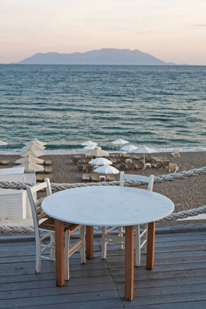 istock Restaurant table and chairs with a relaxing view of Samothraki island, Greece. 689051962