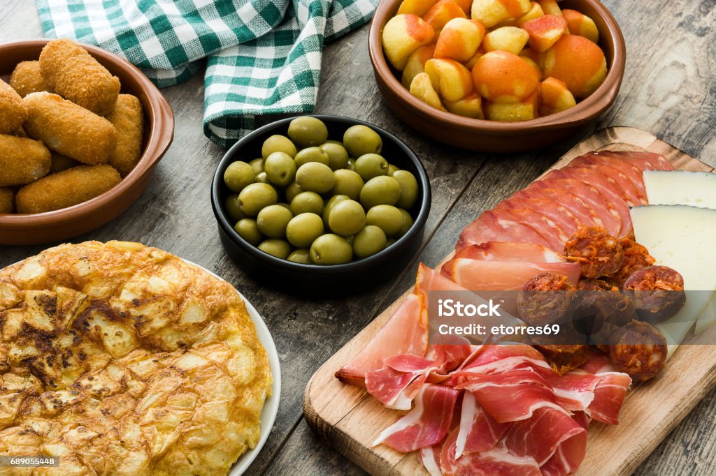 Traditional spanish tapas Traditional spanish tapas. Croquettes, olives,  ham and patatas bravas on wooden background Spain Stock Photo