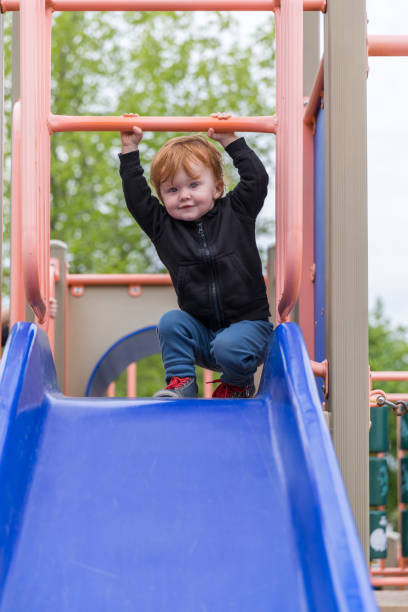 istock Baby Boy Sliding on Slide at the Park 689058228