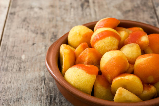 Patatas bravas Patatas bravas in bowl on wooden background patatas bravas stock pictures, royalty-free photos & images