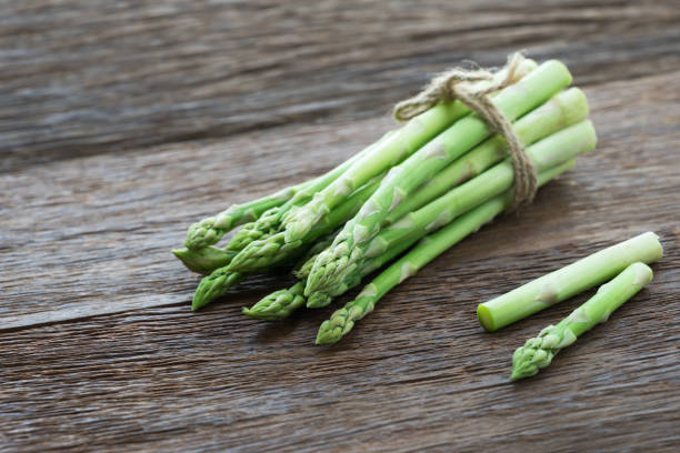 istock Bunch of fresh asparagus on wood table. 689062160