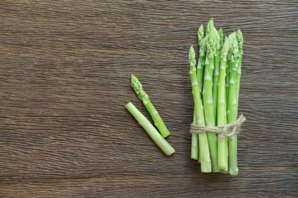 istock Bunch of fresh asparagus on wood table. 689062178