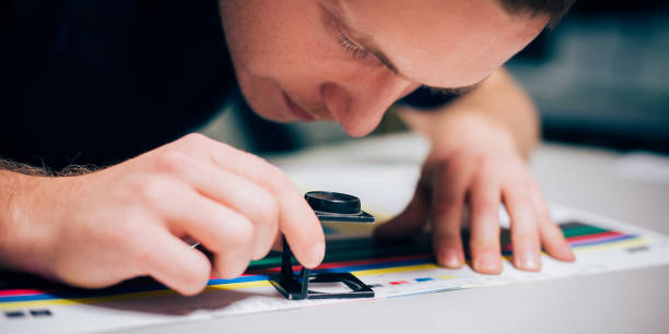 istock Worker in printing and press centar uses a magnifying glass 689068464