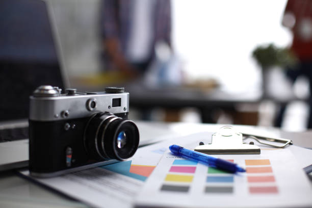 istock Laptop and camera on the desk with folder 689073192