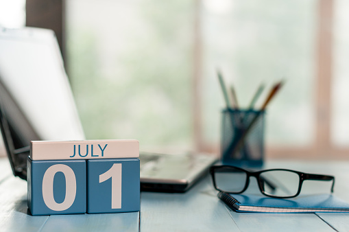 1er de julio. día del mes 1, calendario de color madera en el fondo del lugar de trabajo de negocios. Concepto de verano. Espacio vacío para el texto photo