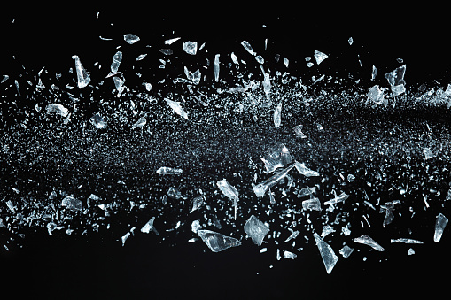 Shattered crystals or glass in motion on black background, studio shot.