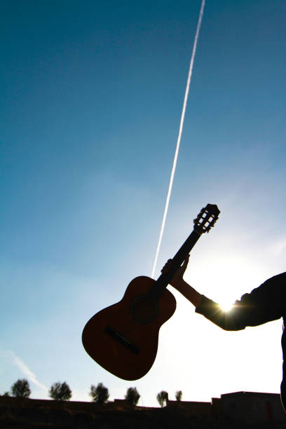 istock man with a guitar  against blue sky 689083188