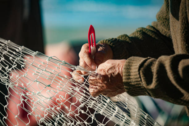 Fisherman sewing fishing net