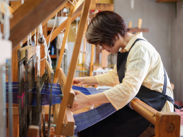 Orimono Textile Shop in Okinawa Japan Japanese woman workers in a traditional Orimono textile shop in Okinawa, Japan. linen fabric swatch stock pictures, royalty-free photos & images