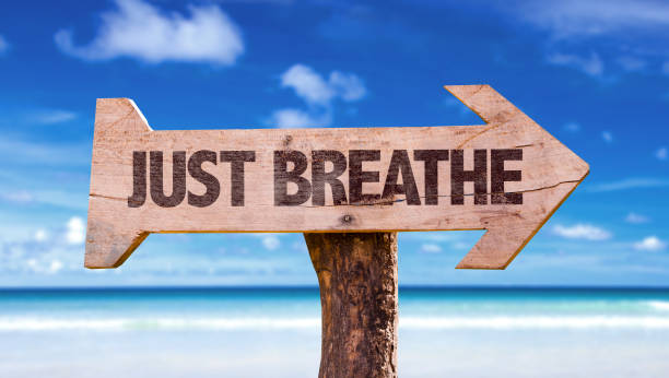 Just Breathe directional sign Just Breathe directional sign with a beach no brainer sign stock pictures, royalty-free photos & images