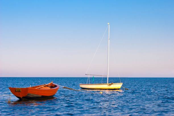 istock Rowing boat and sailing ship moored at the blue sea 689090140