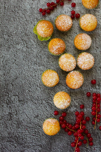 istock Muffins with red currants on a wooden background. View from above. 689097240