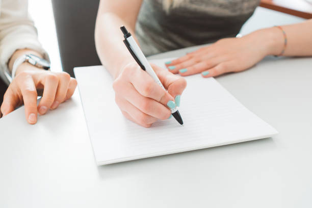 istock Young female hand writing on a paper 689097862