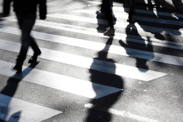 istock Blurry zebra crossing with pedestrians making long shadows 689142026
