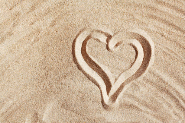 istock Drawn on sand picture of heart 689163154