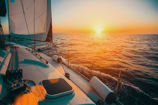 Sailing boat in the sea during awesome sunset. Luxury yacht and cruise holiday.