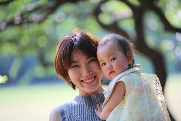 istock Mother holding her baby at spring park 689191146
