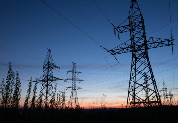 istock High voltage electricity pylons against sunset. 689206076