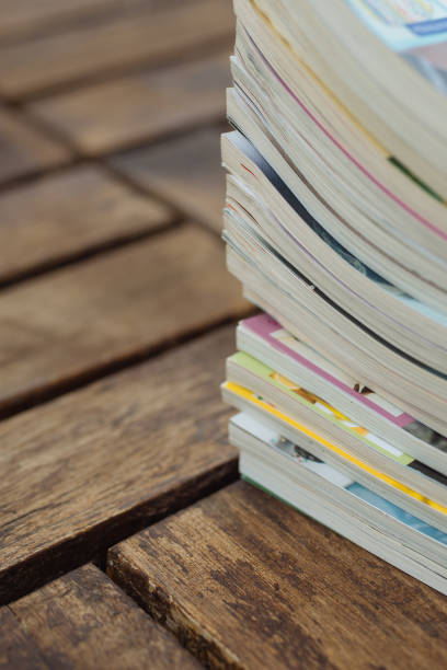istock Stack of old magazines on wooden background 689215636