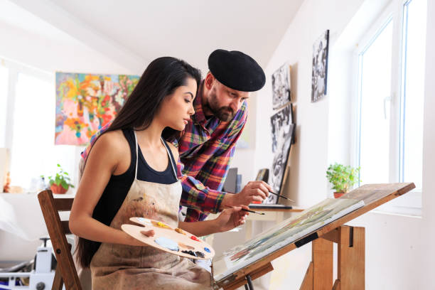 istock Fine art painter and female apprentice working in atelier 689215984