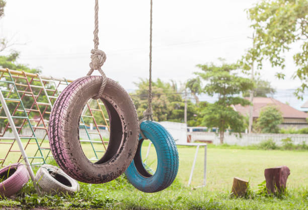 Vrsac, Serbia - June 04, 2020: A children's playground made of old tires. Two children's swings made of a car wheel.