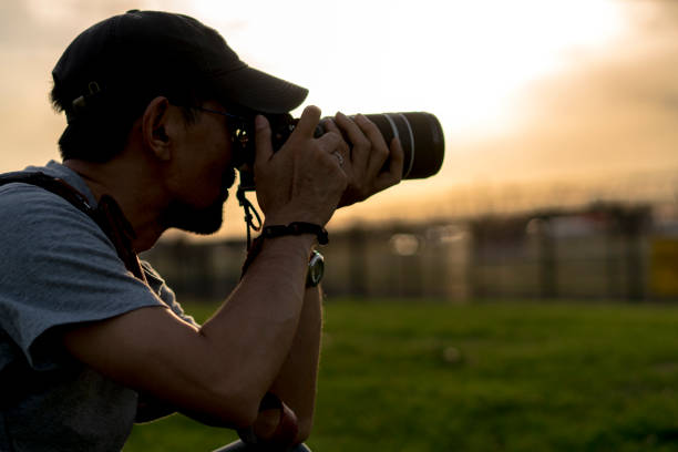 istock photographer taking pictures at sunset 689249720