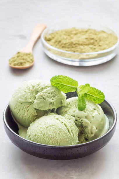 istock Matcha green tea ice cream balls in black bowl, vertical 689252084