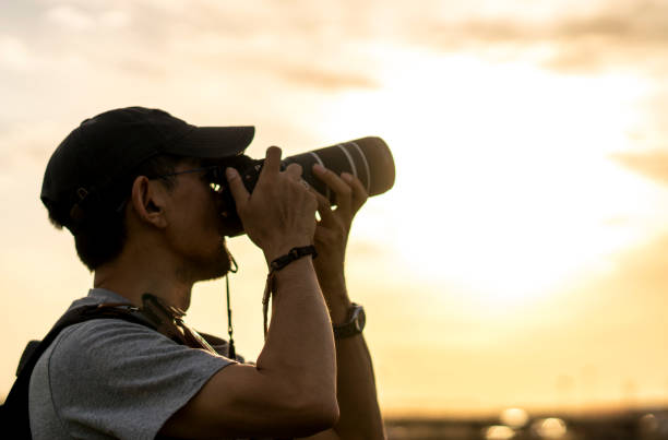 istock photographer taking pictures at sunset 689252940