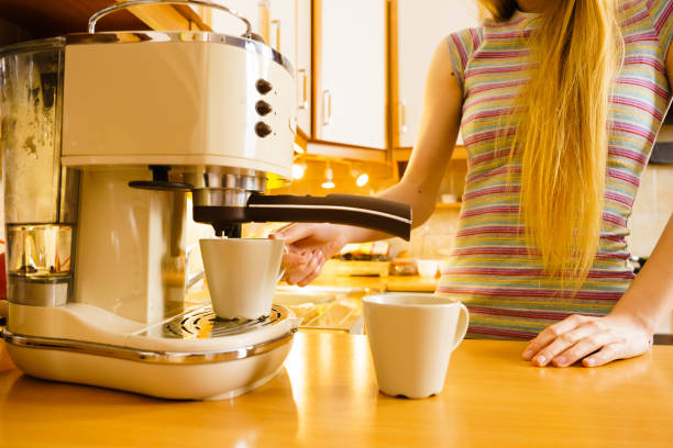 istock Woman making hot drink in coffee machine 689260334