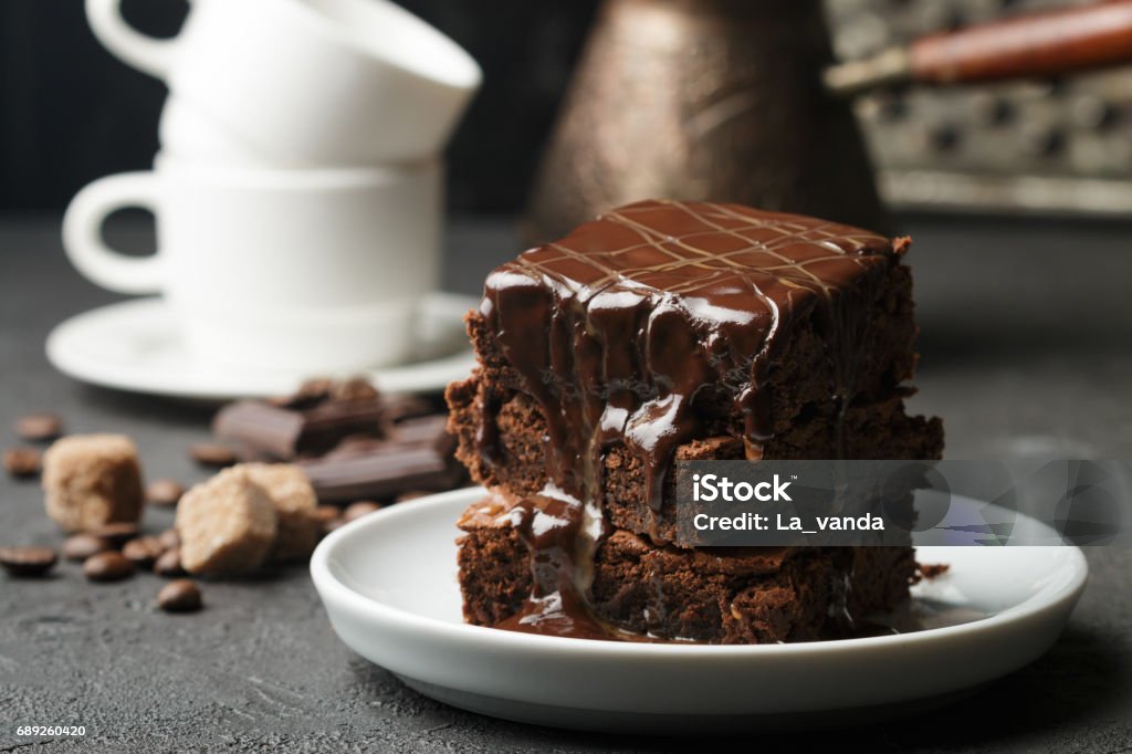 Delicious homemade brownie with chocolate sauce and caramel on the table. Selective focus Brownie Stock Photo