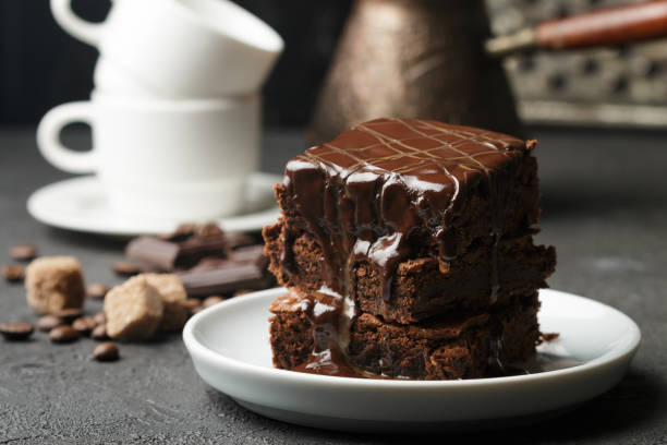 Delicious homemade brownie with chocolate sauce and caramel on the table. Selective focus Delicious homemade brownie with chocolate sauce and caramel on the table. Selective focus dessert topping photos stock pictures, royalty-free photos & images