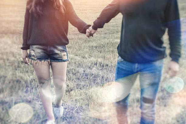 istock Lovers walk hand in hand on romantic evening sun, romantic atmosphere. 689263948