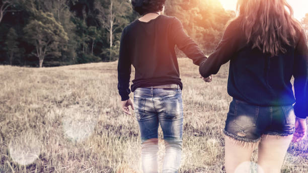 istock Lovers walk hand in hand on romantic evening sun, romantic atmosphere. 689264406