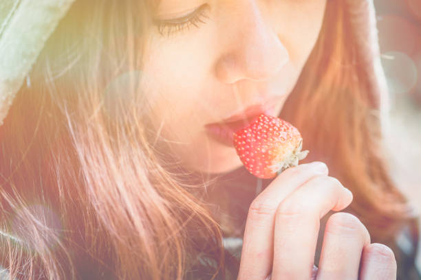 Strawberry close-up against a bright blue sky with sun rays. The concept of healthy food, vitamins, agriculture, market, strawberry sale.