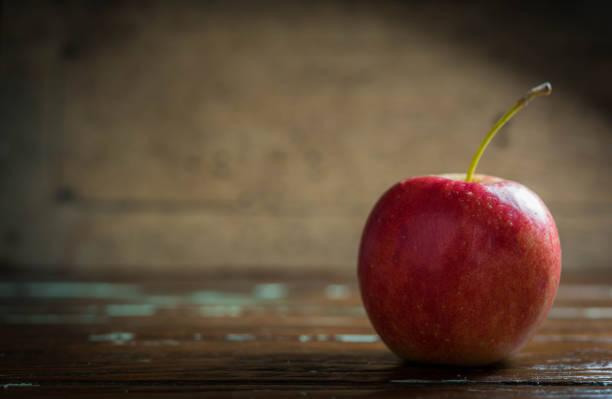 istock single red apple on wooden background 689278546