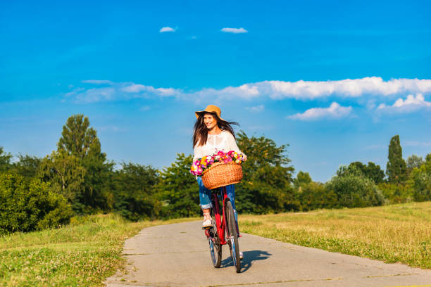 istock Young smiling woman rides a bicycle in counrtyside 689278800