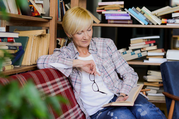 istock Beautiful woman with glasses reading a book 689281788
